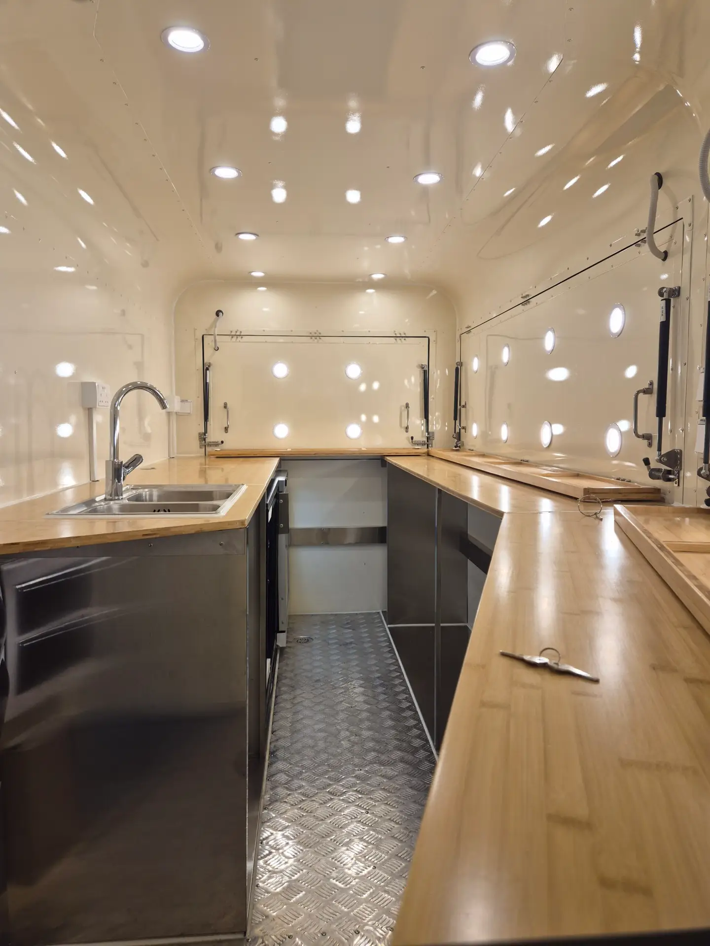 Food van interior showing fitted kitchen with LED lighting and stainless steel counters